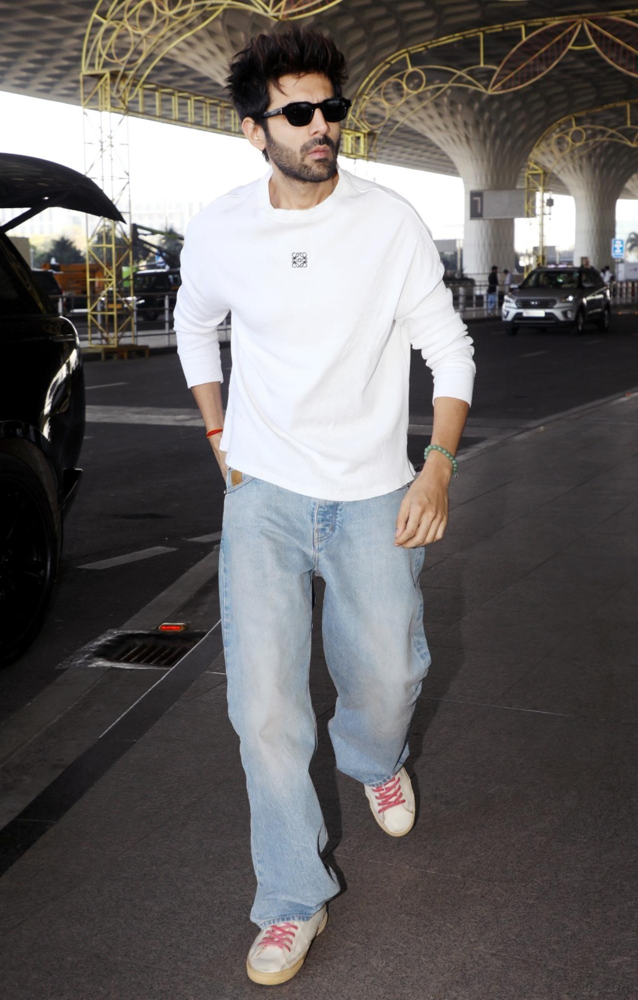 Amid the promotions of TMMTMTTM, Kartik Aaryan was spotted at the airport in a casual white t-shirt and blue jeans.